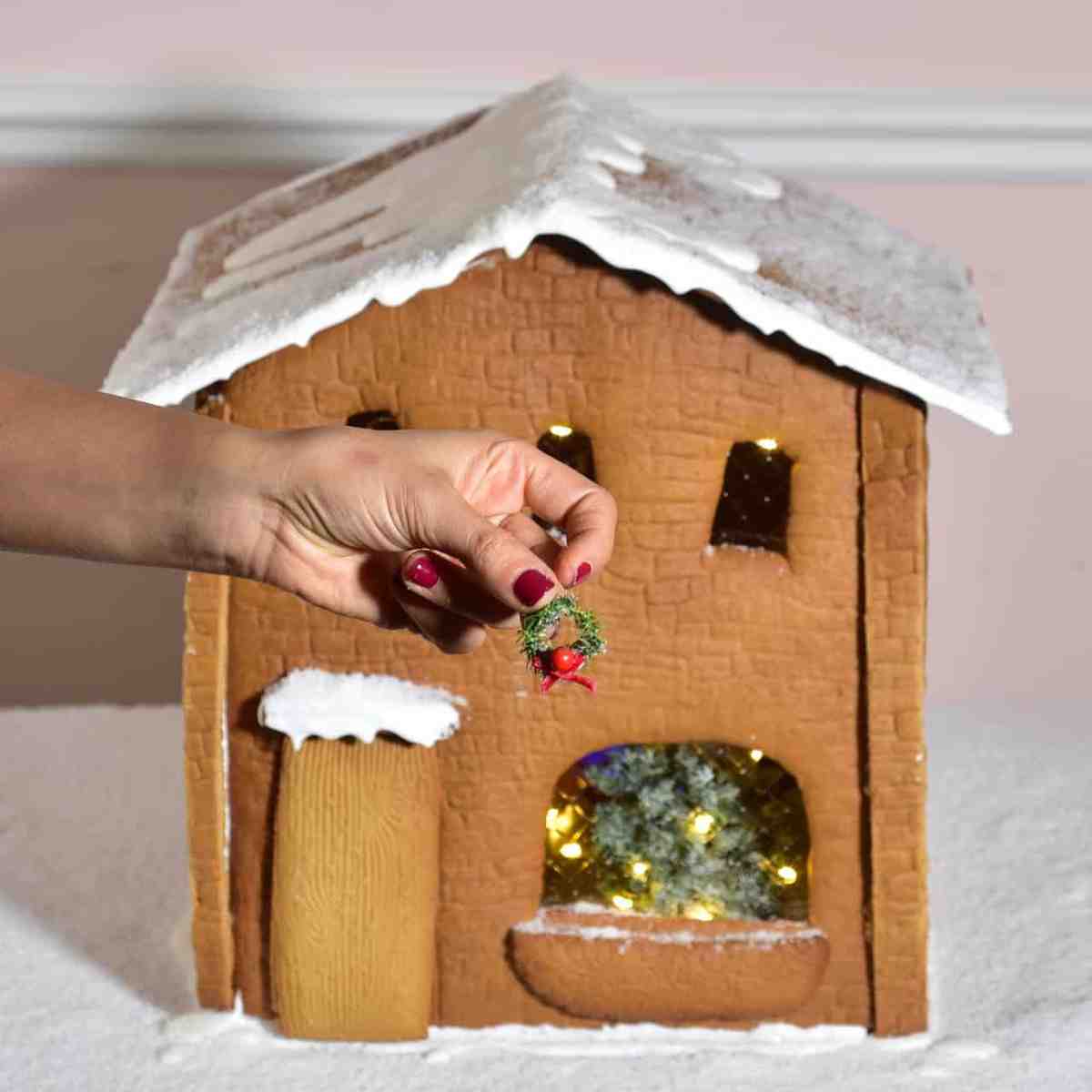 Adding a little green wreath on the gingerbread house