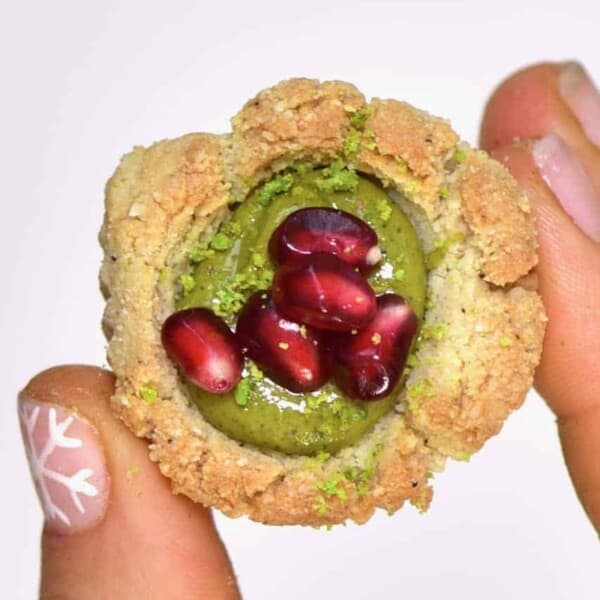 Delicious gluten-free, vegan bite-size snacks; almond & pistachio thumbprint cookies recipe. Not only are they easy to make- they can either be baked or kept as a no-bake cookie recipe!