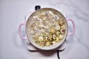 A pot with boiling water and lots of quail eggs