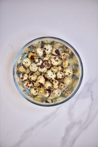 Quail eggs in a bowl with water