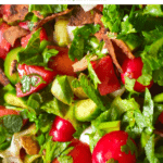 A close up of fattoush salad with mint cucumber tomatoes and toasted pita bread
