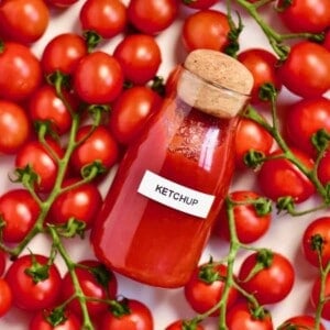 Homemade ketchup in a bottle and tomatoes