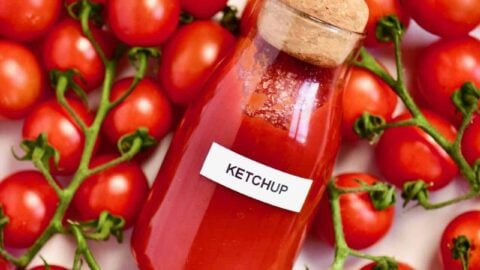 Homemade ketchup in a bottle and tomatoes