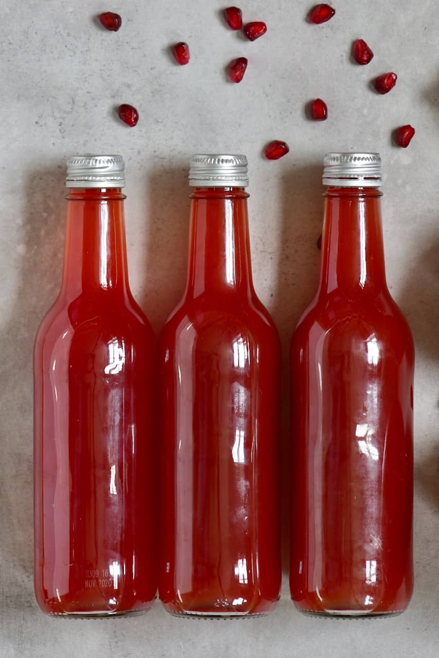 fizzy pomegranate kombucha diy, in glass bottles