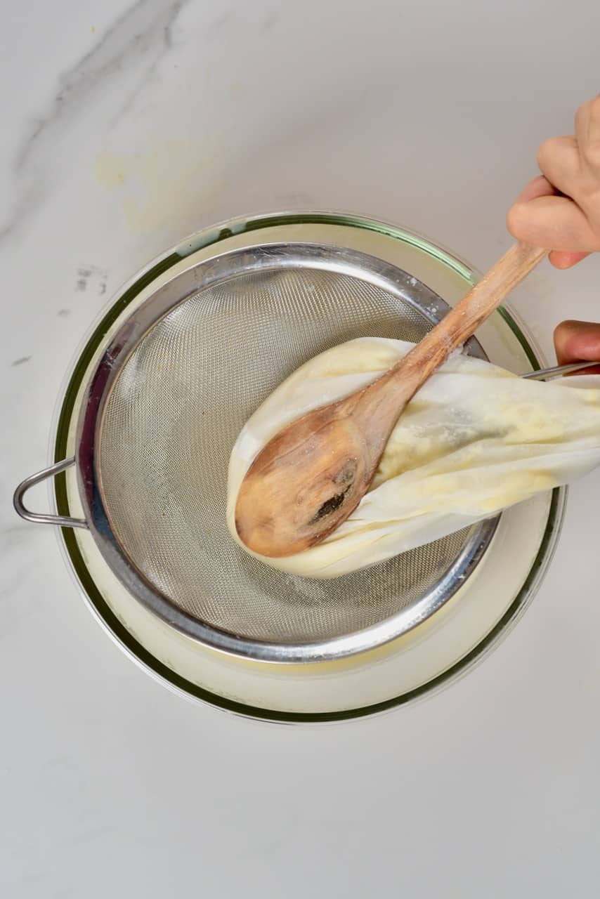 squeezing out soy milk from nut milk bag