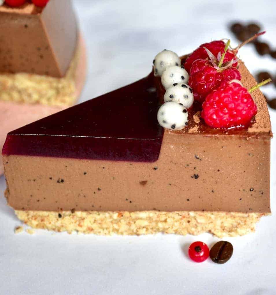 a slice of mocha red wine tart with dragonfruit pearls and red berries