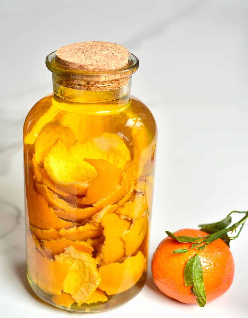 A jar filled with vinegar and citrus peel