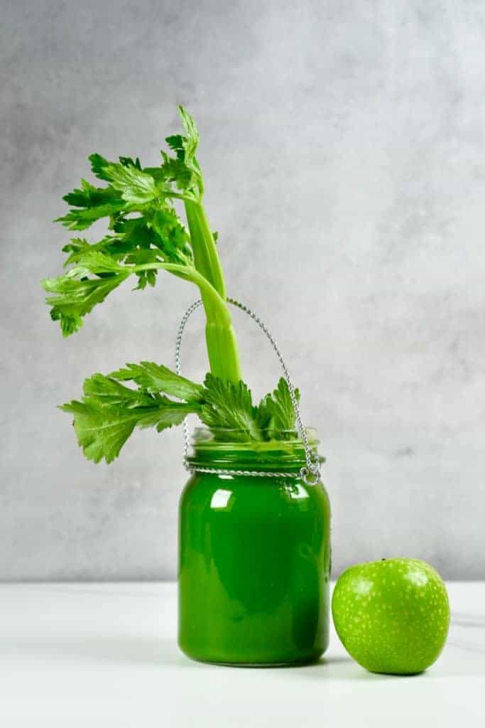Celery juice in a jar and an apple