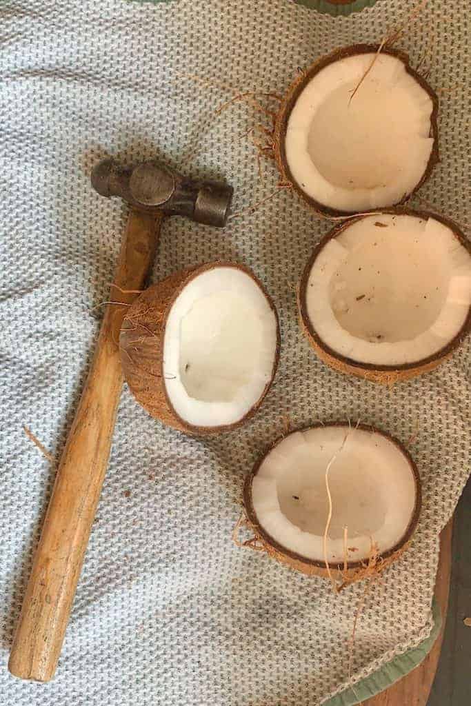 Two open coconuts and a hammer
