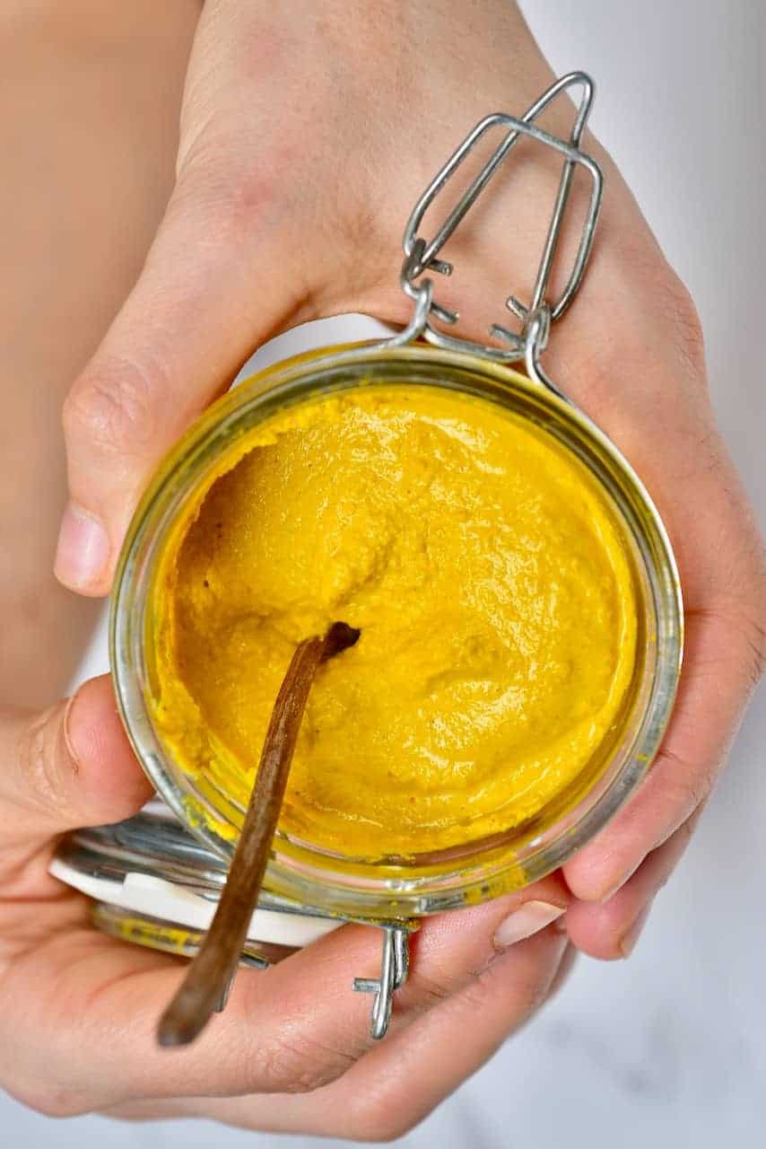 Mustard and spoon in a jar