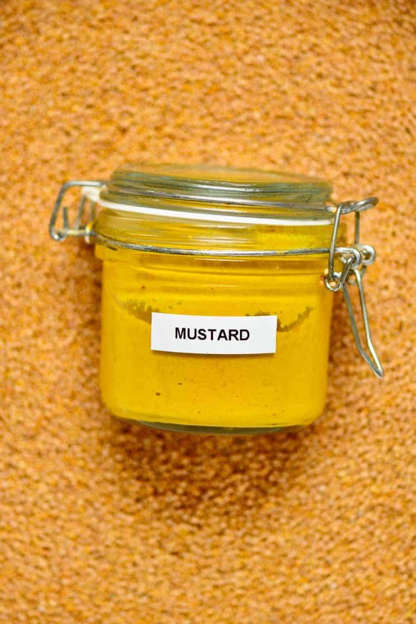 Mustard jar on top of mustard seeds