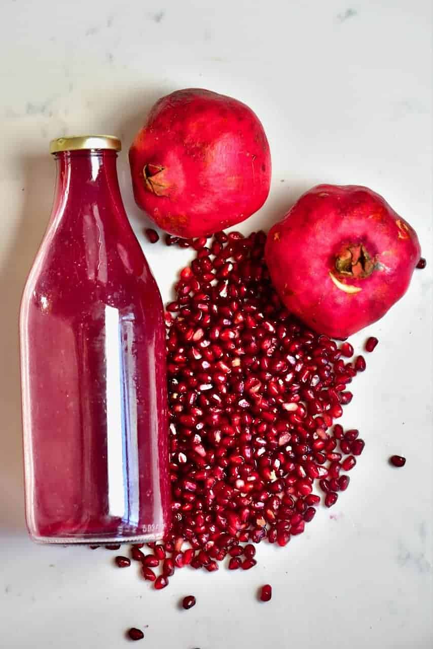 Pomegranate fruit seeds and juice in a bottle