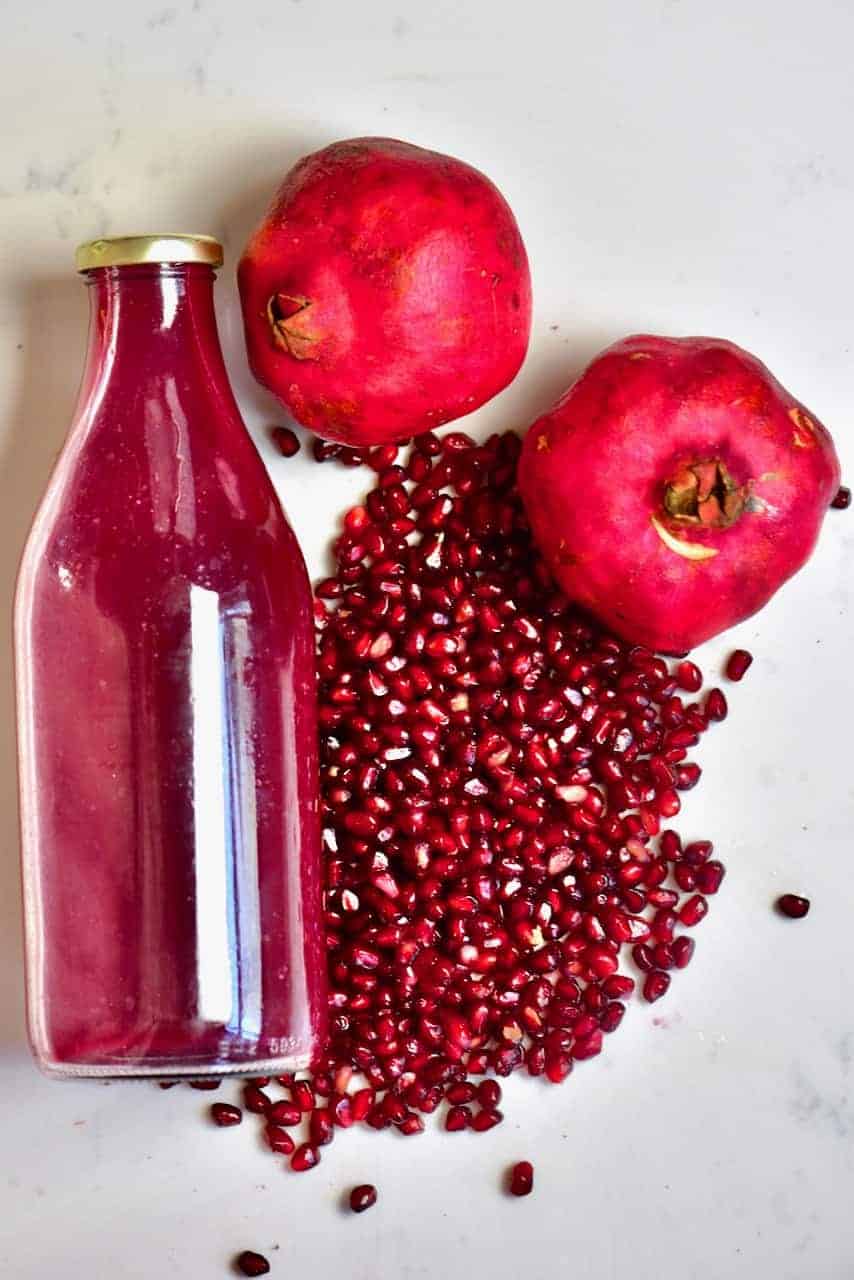 Pomegranate fruit seeds and juice in a bottle