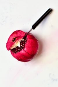 Opening the top of a pomegranate