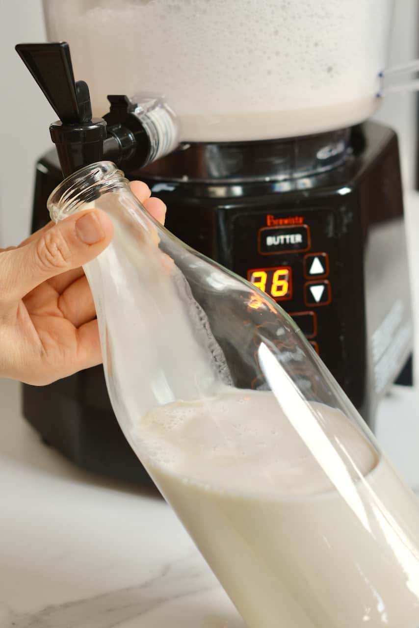 Pouring dairy-free tiger nut milk from NutraMilk machine