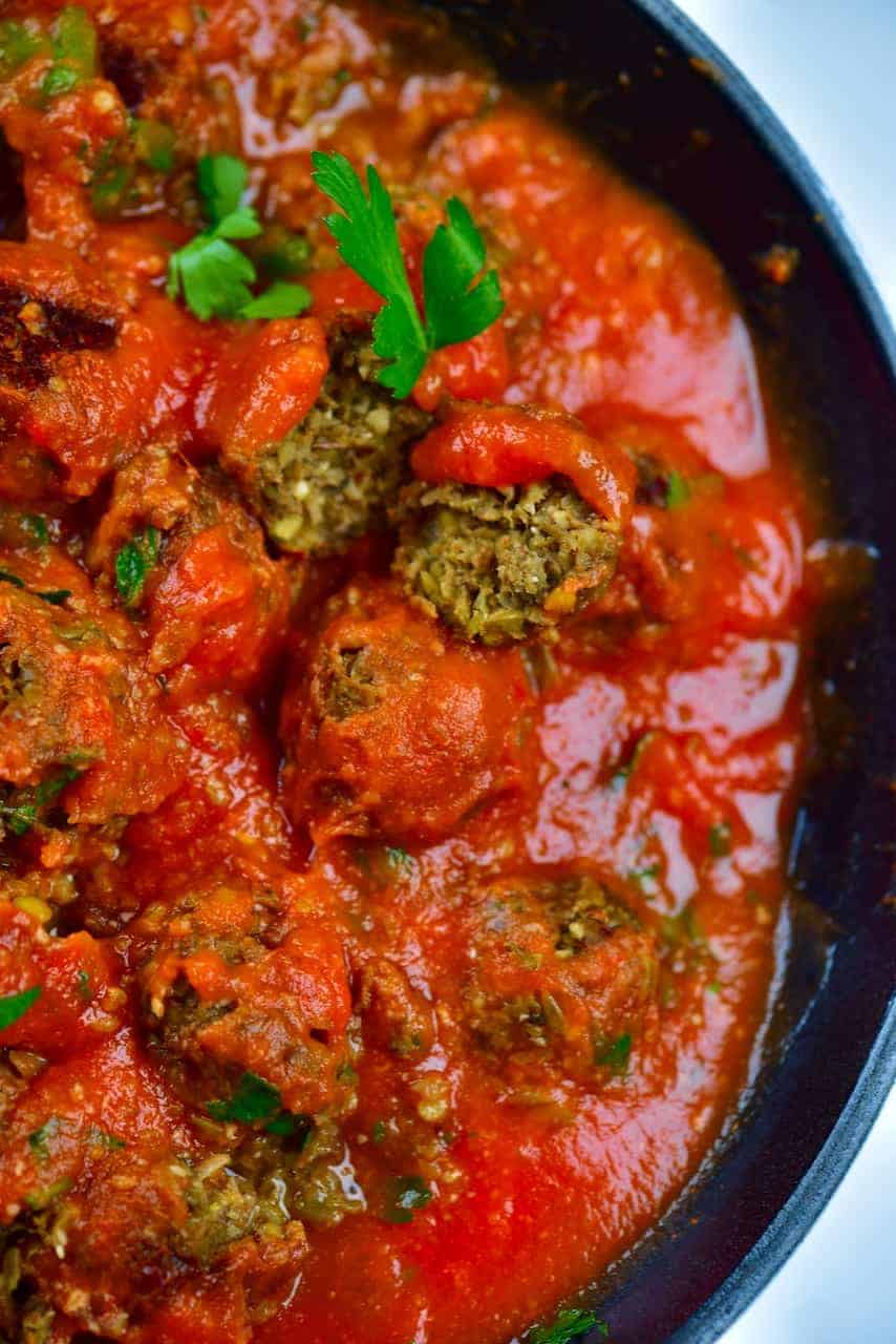 Showing lentil meatball in pan with tomato sauce