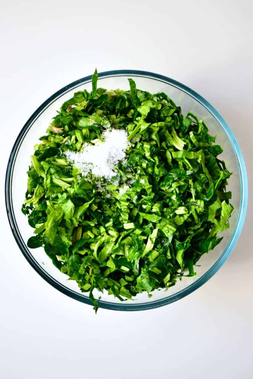 Chopped spinach and salt for Spinach Fatayer