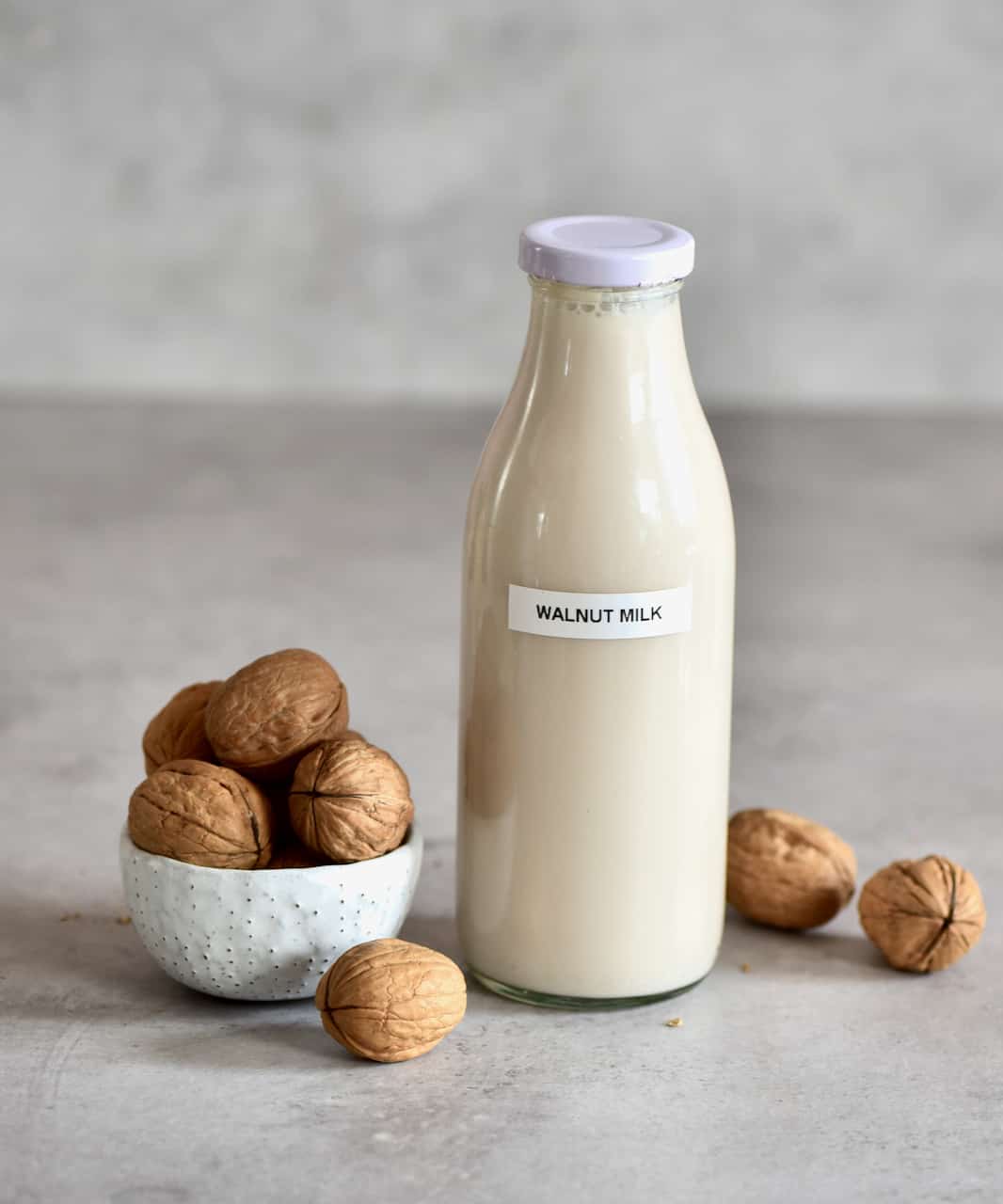 Walnut milk in a bottle and walnuts
