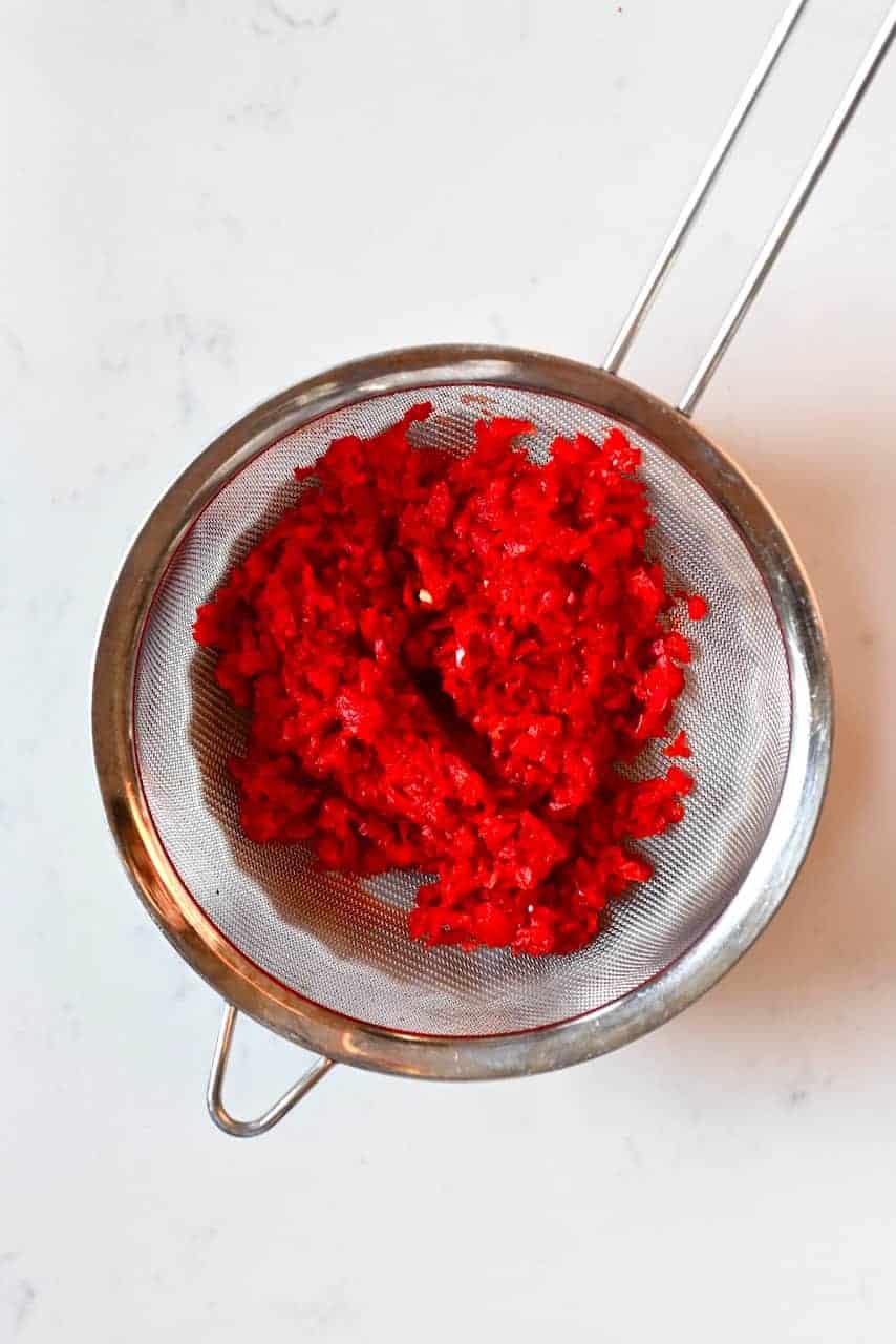Blended red peppers in a sieve