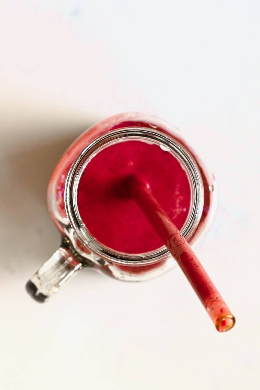 berry smoothie in a jar with a straw