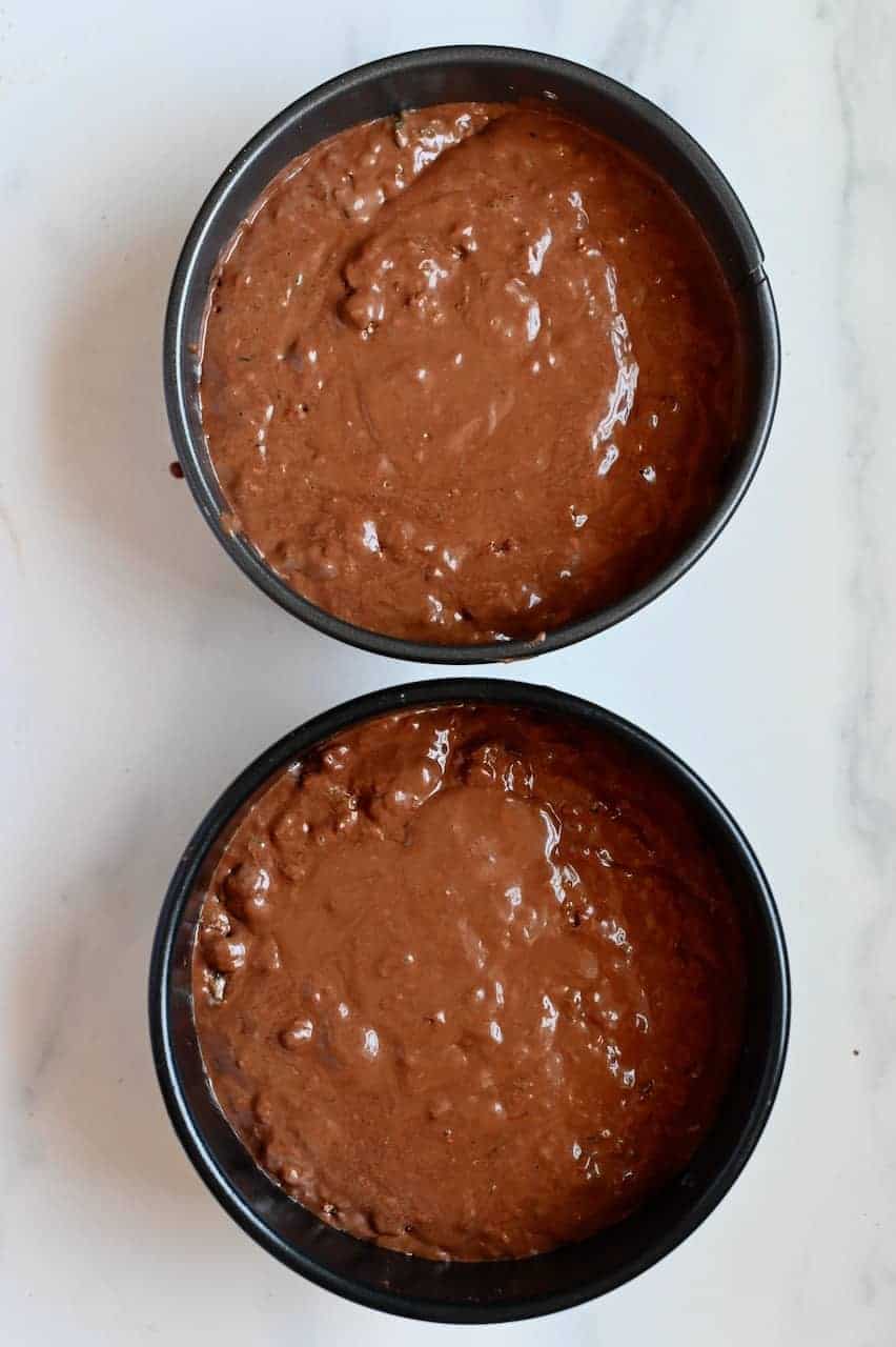 Chocolate cake batter in two tins