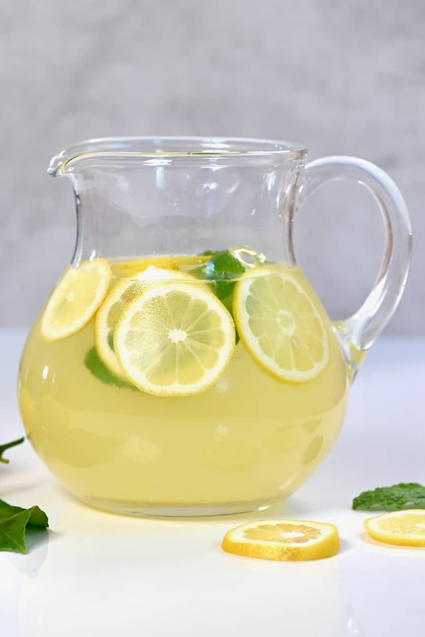 Fresh lemonade jug with lemon slices on the side