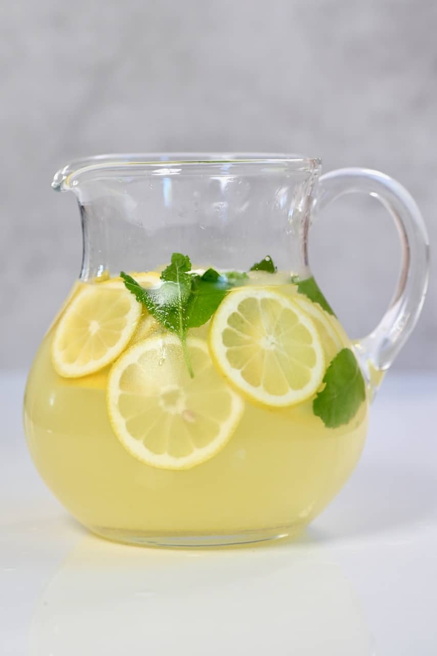 Fresh lemonade jug with mint and lemon slices