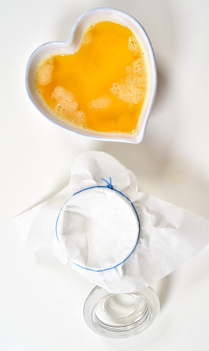 Melted butter in a bowl and a jar with a cloth