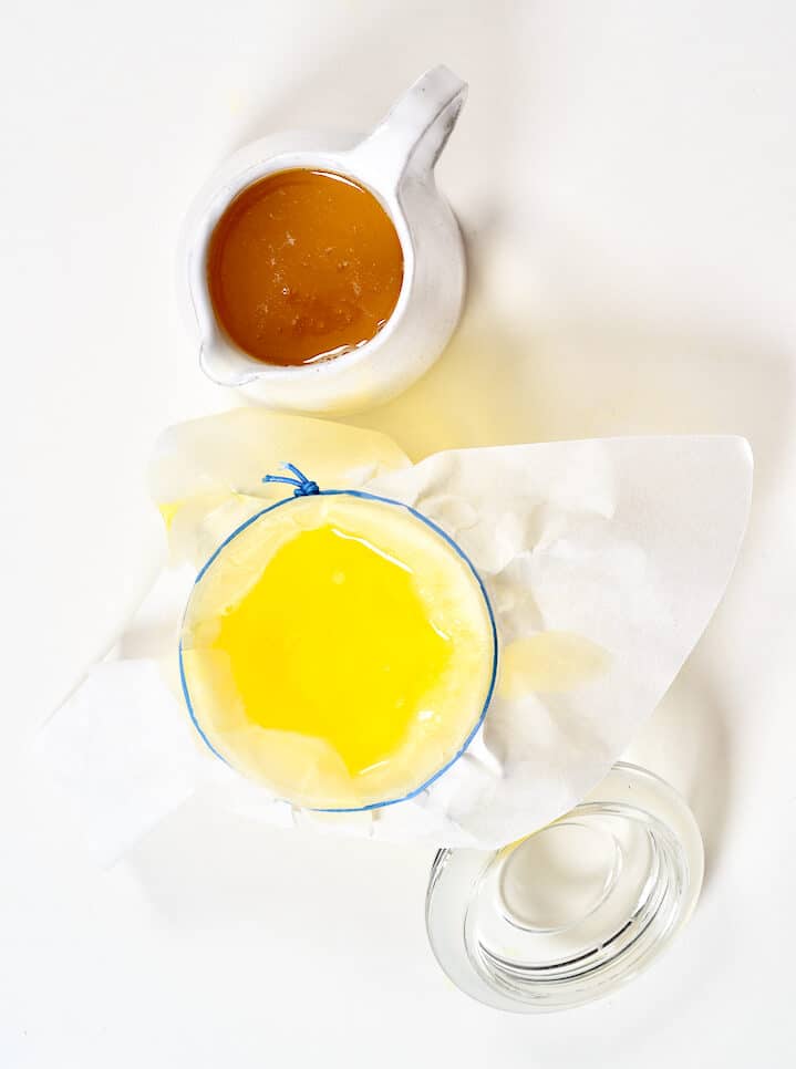 Melted butter in a small jug and a jar with a cloth