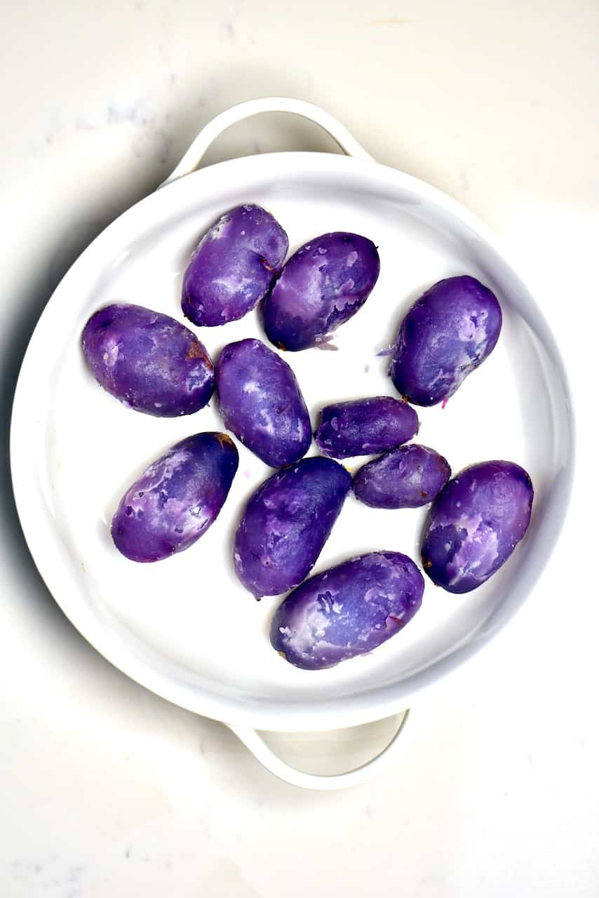 boiled and peeled purple potatoes inside a white bowl