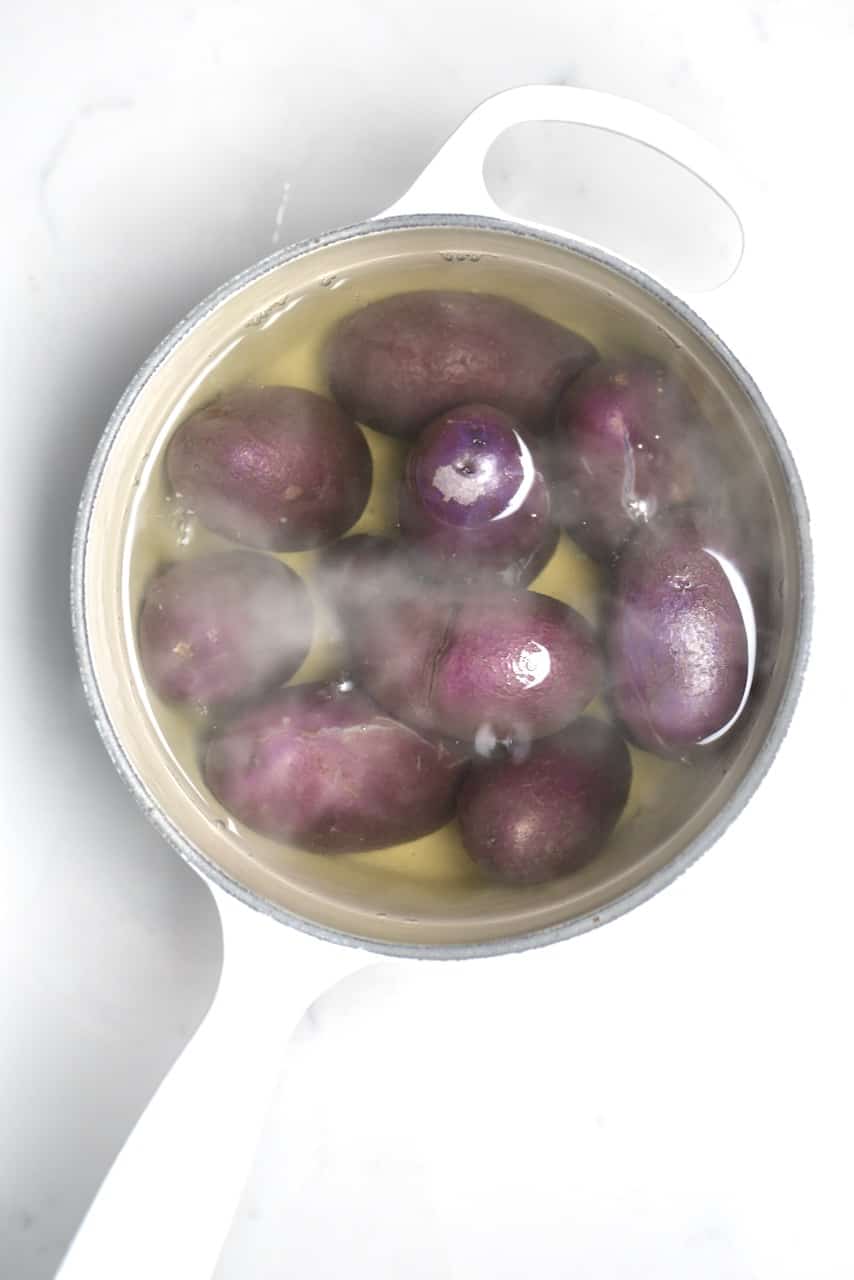 boiled purple potatoes inside a white pot