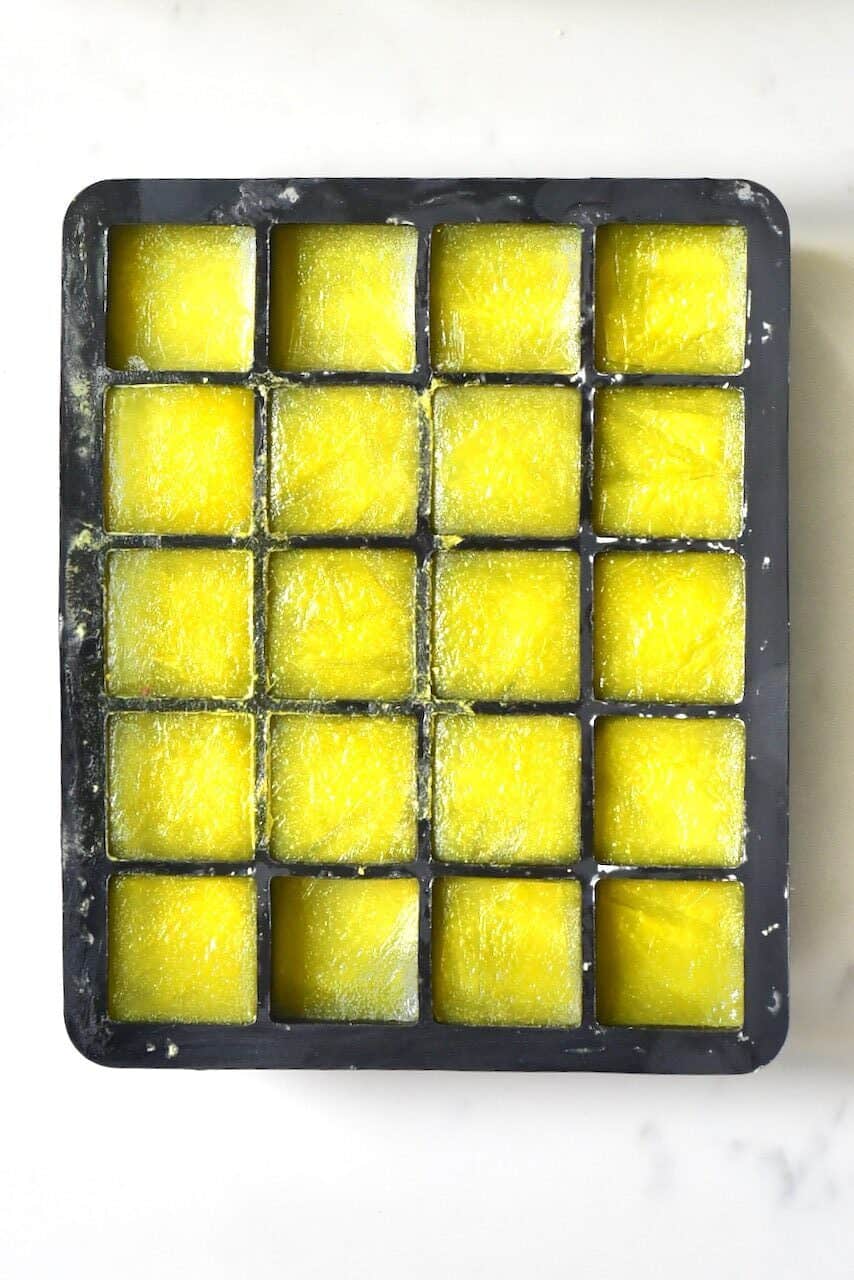 frozen ginger juice inside a black ice cube tray