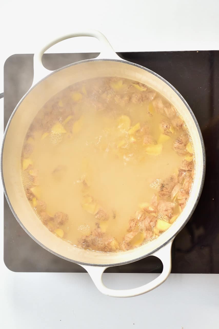 ginger and boiling water in a white pot