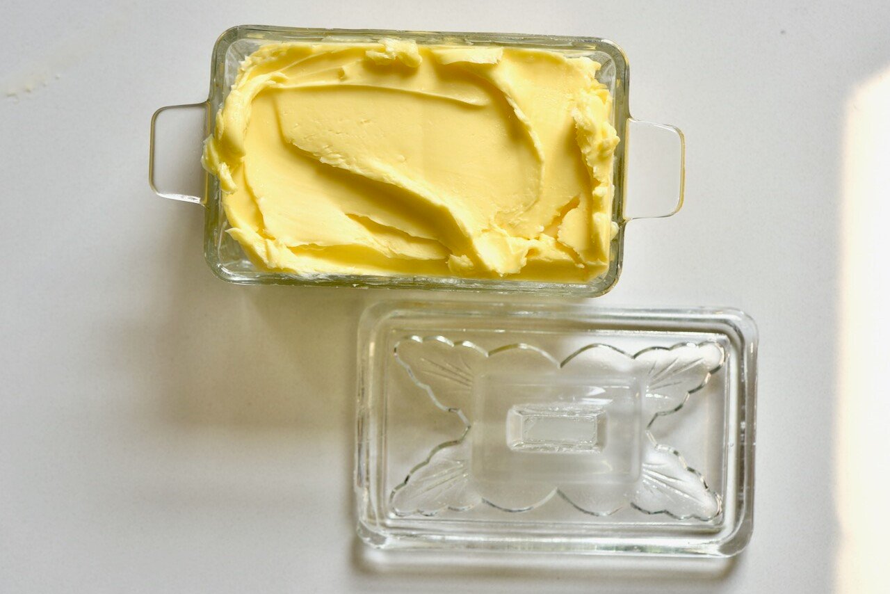 homemade butter in a clear glass container with a lid on the side