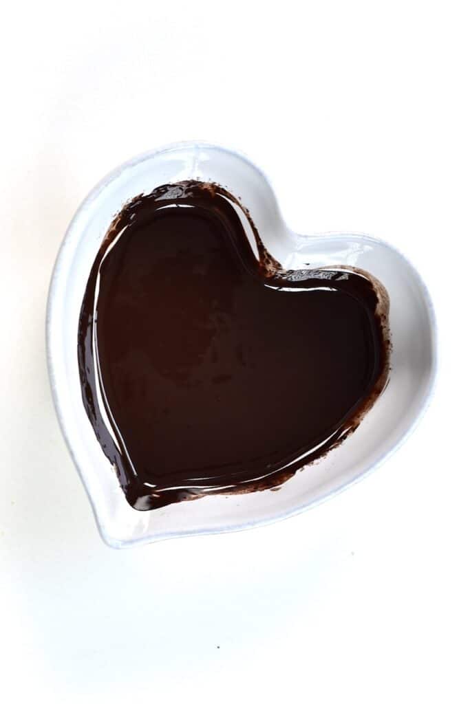 melted dark chocolate in a heart shaped bowl