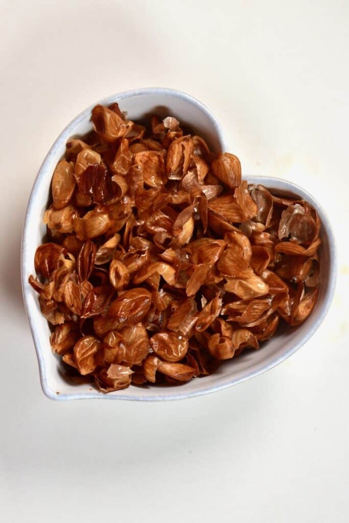 peeled almond skin insdie a heart shaped bowl