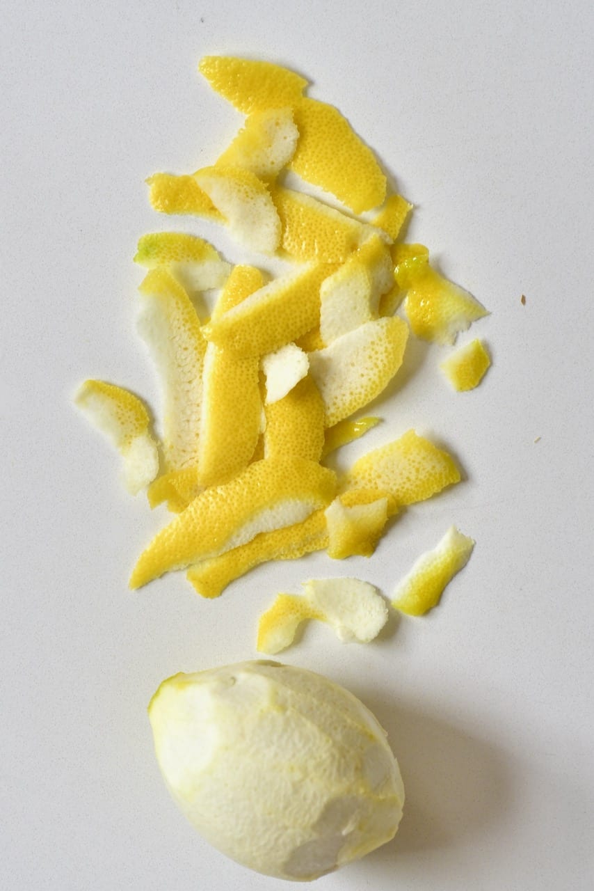peeled lemon and lemon skin on white marble top