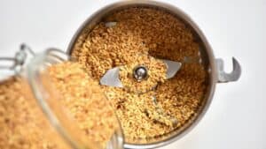 pouring golden Flaxseed into a spice grinder