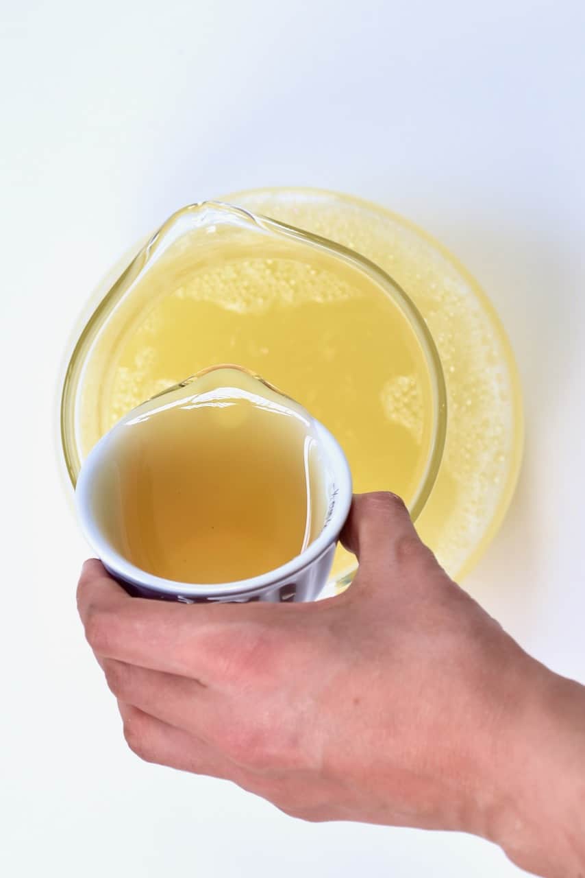 pouring honey on ginger lemonade