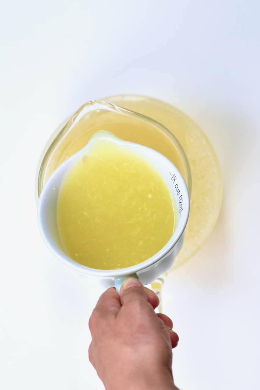 pouring lemon on cooled ginger water