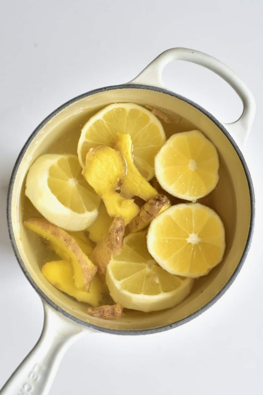 slices of lemon and ginger in water in a white pot