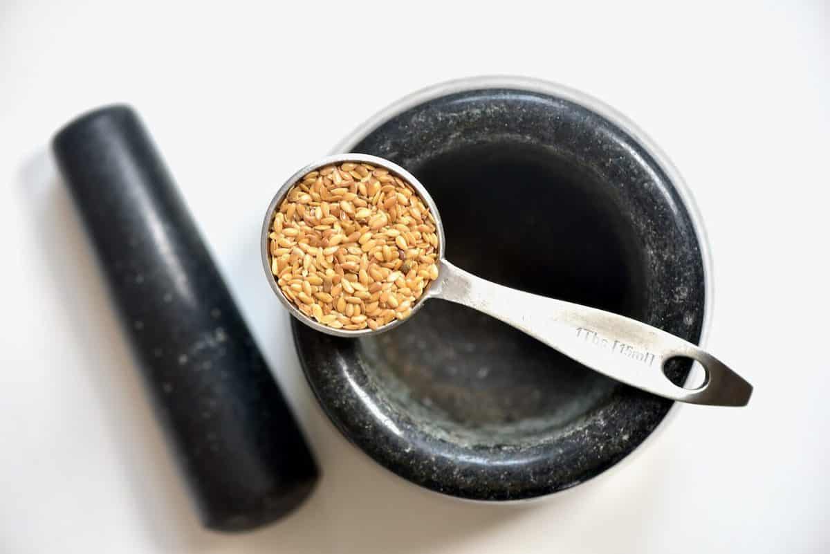 https://www.alphafoodie.com/wp-content/uploads/2020/06/tablespoon-of-golden-Flaxseed-and-a-morter-and-pestle-e1591958133663.jpeg