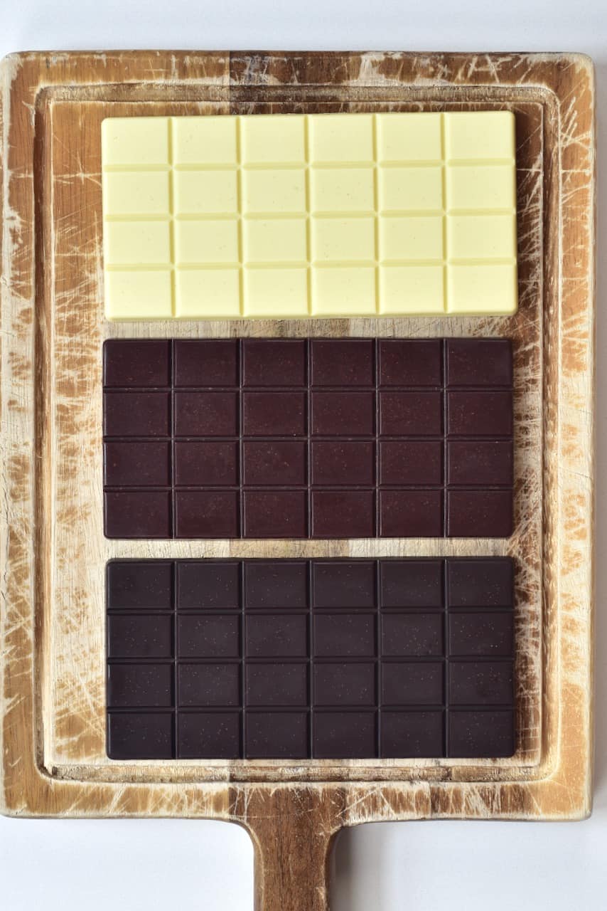 white milk and dark chocolate bars on cutting board