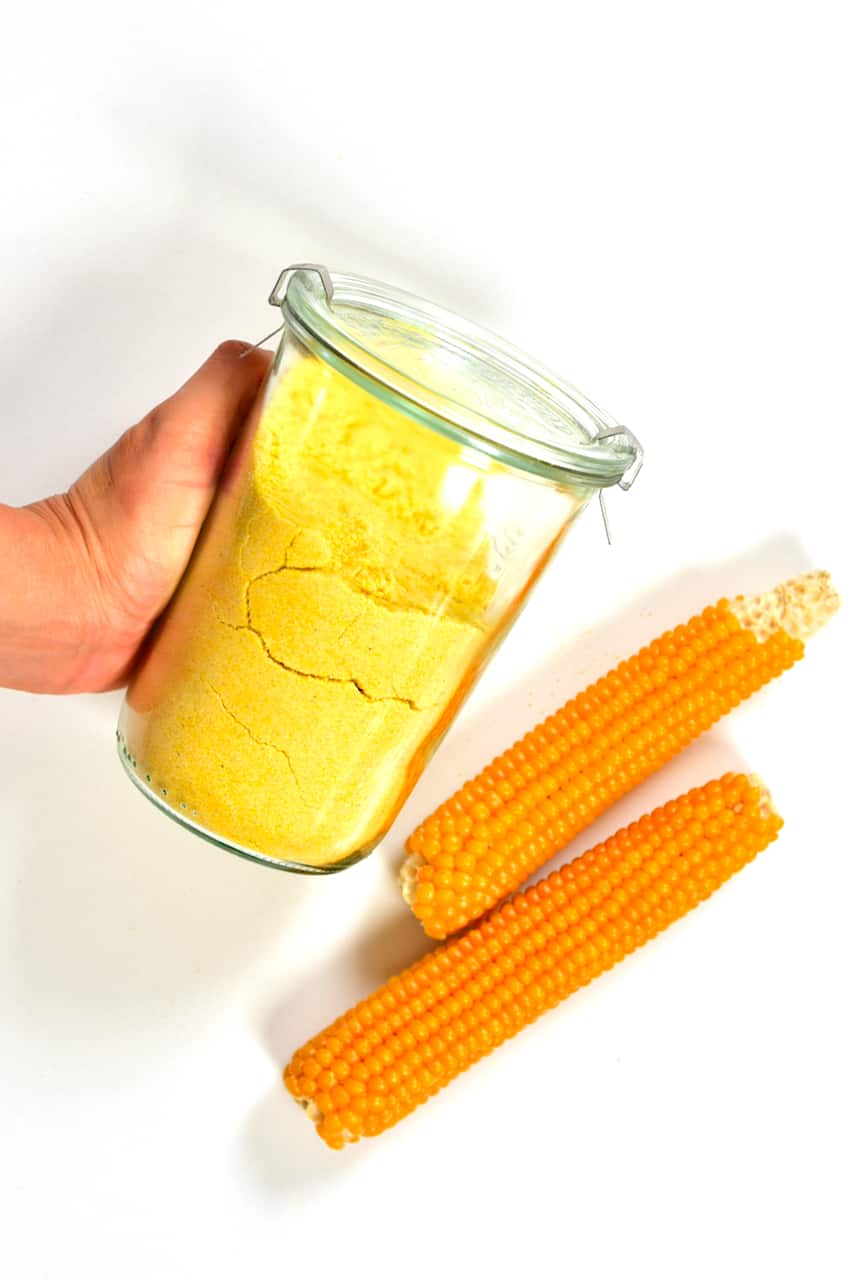 A jar of corn flour and two corn ears
