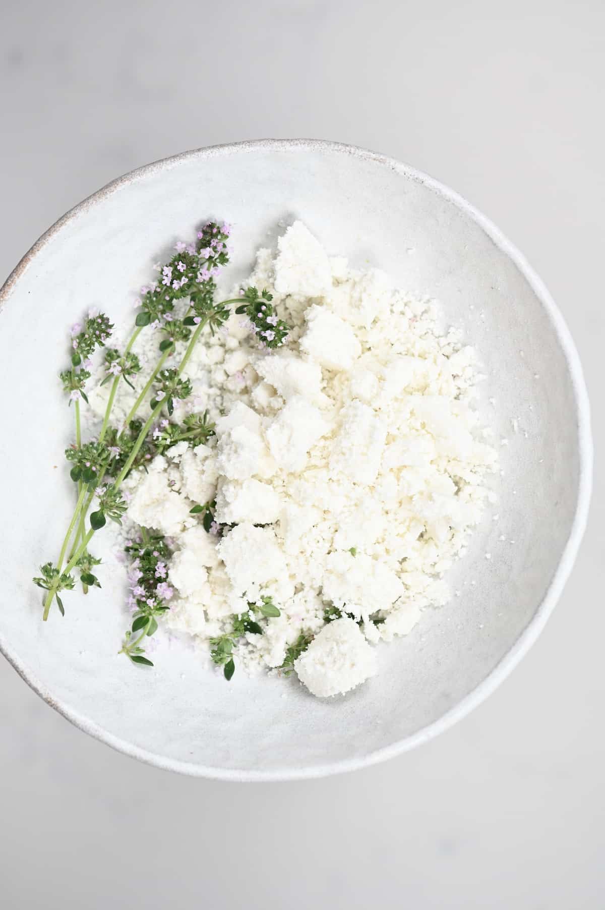 Crumbled goats cheese with herbs in a white plate