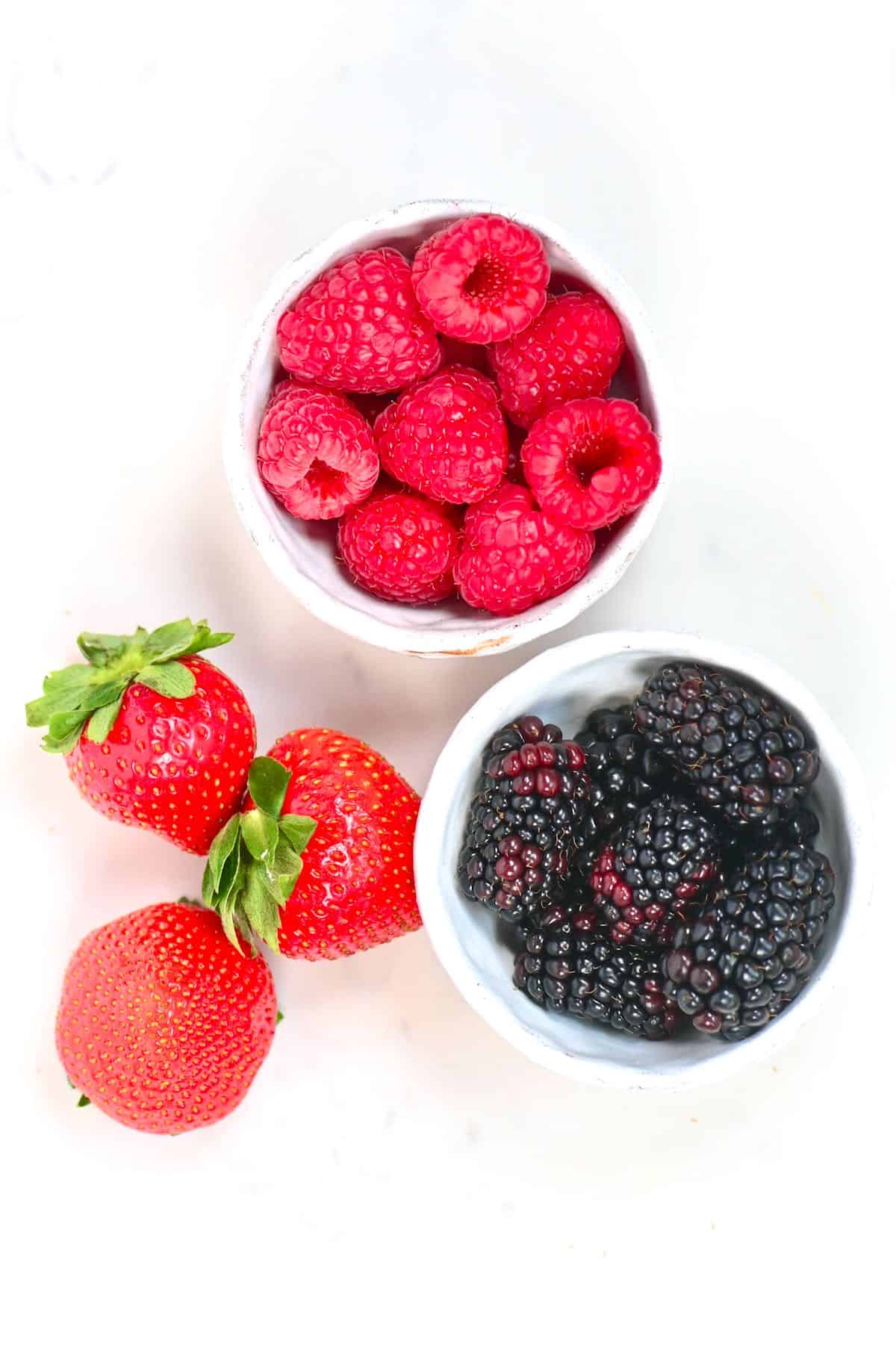 A handful of strawberries raspberries and blackberries