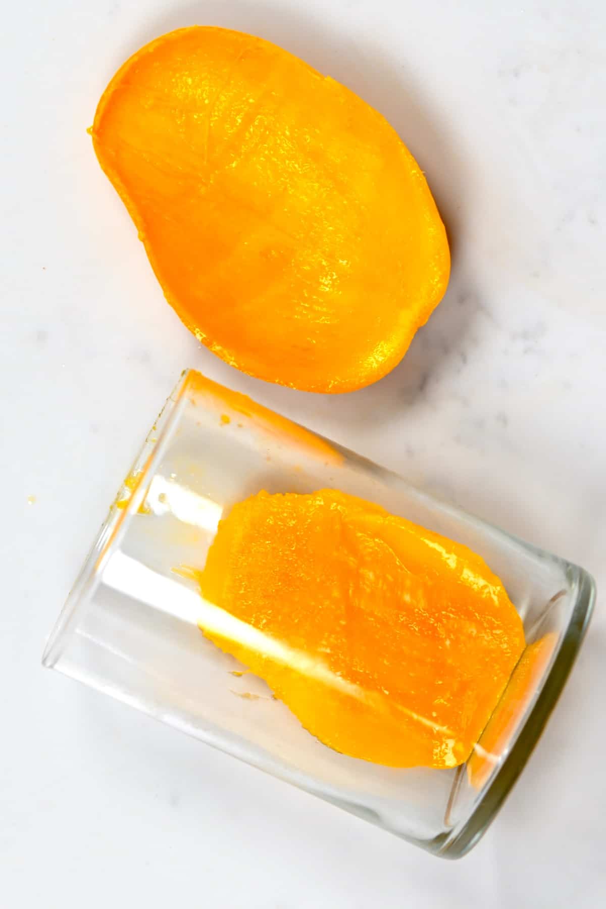 mango peel and ripe mango in a cup