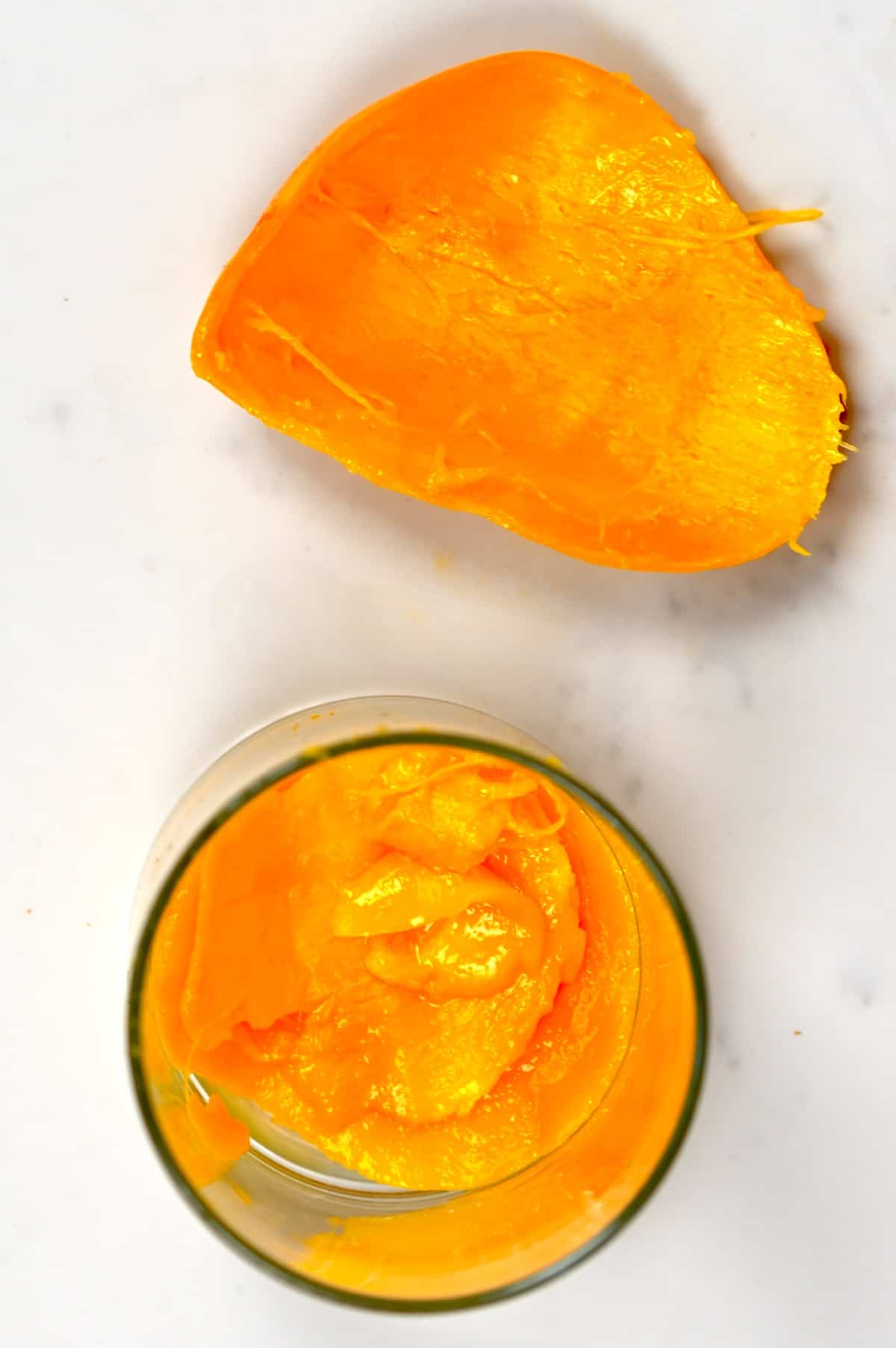 mango peel and ripe mango in a cup