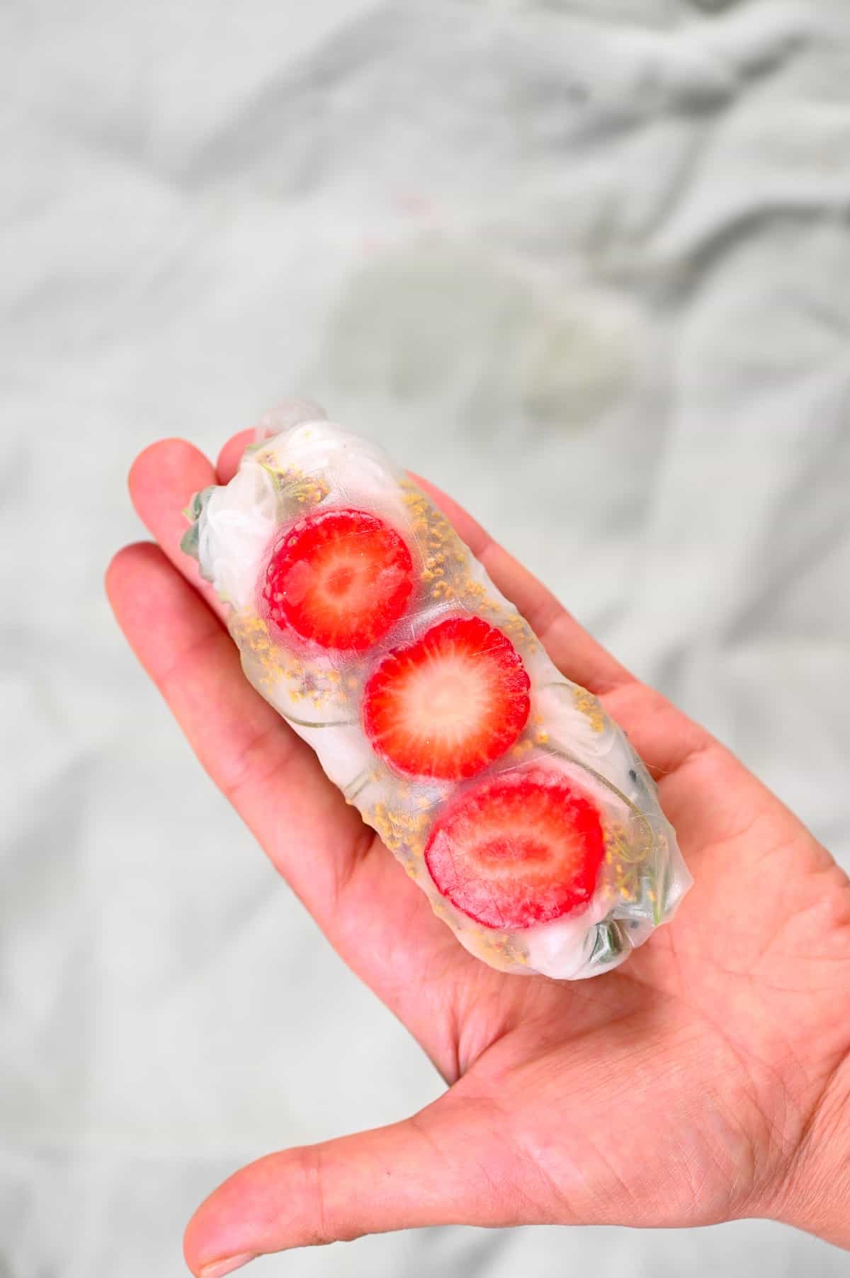 holding strawberry rice paper roll