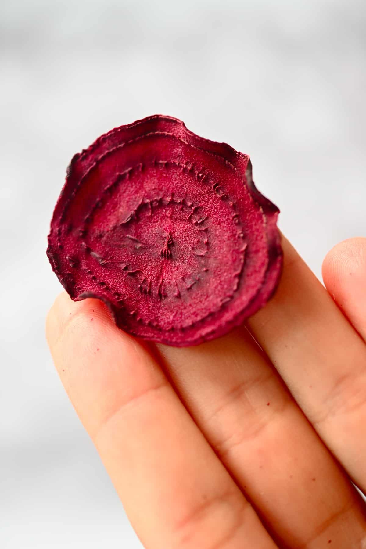 A beetroot chip in a hand